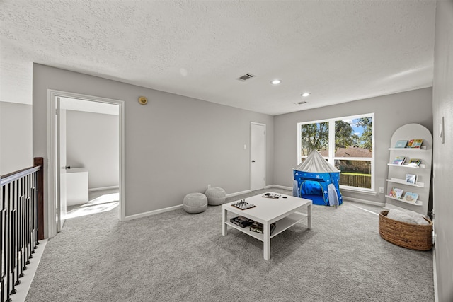 living room featuring light colored carpet and a textured ceiling