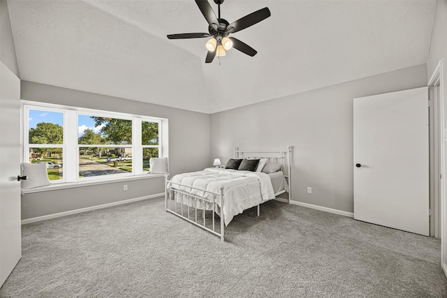 bedroom with ceiling fan, carpet floors, and lofted ceiling