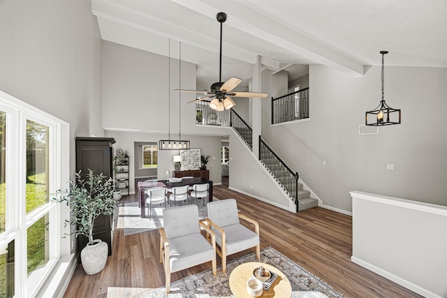 interior space with hardwood / wood-style flooring, ceiling fan with notable chandelier, beam ceiling, and high vaulted ceiling