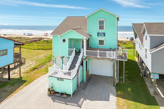 view of front of property featuring a beach view, a water view, and a garage