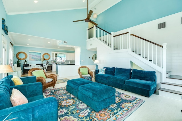 living room with high vaulted ceiling, light hardwood / wood-style flooring, ceiling fan, ornamental molding, and beam ceiling