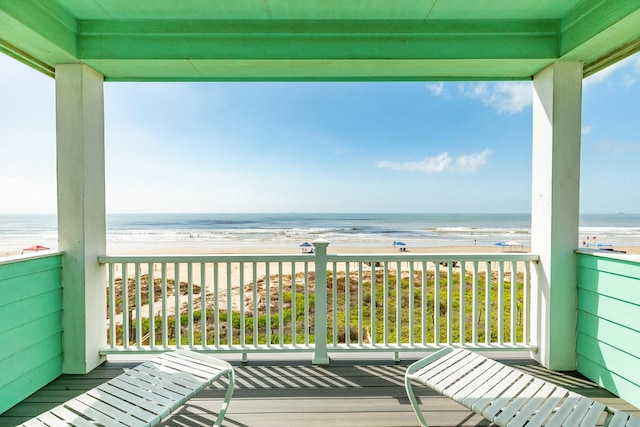 balcony with a water view and a beach view