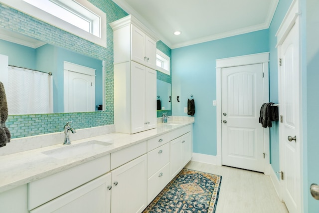 bathroom with ornamental molding, vanity, tasteful backsplash, and a healthy amount of sunlight