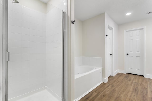 bathroom with wood-type flooring and separate shower and tub