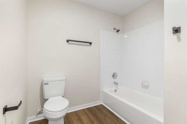 bathroom with hardwood / wood-style flooring, tiled shower / bath combo, and toilet