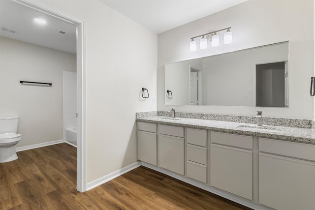 full bathroom with toilet, vanity, bathtub / shower combination, and hardwood / wood-style flooring