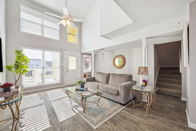 living room with a textured ceiling, high vaulted ceiling, ceiling fan, and dark wood-type flooring