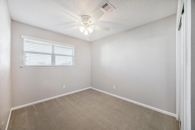 unfurnished room with ceiling fan, carpet, and a textured ceiling