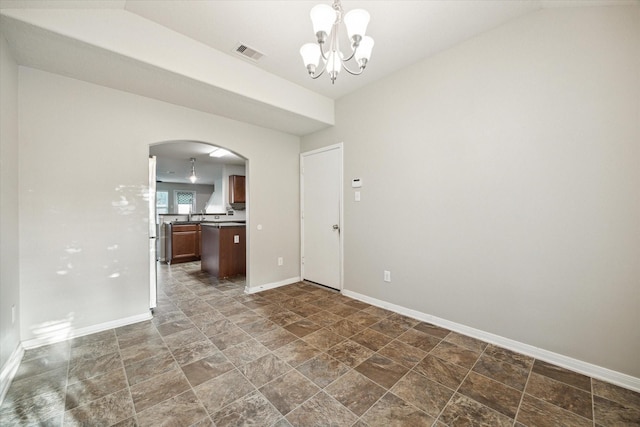 unfurnished room with a chandelier