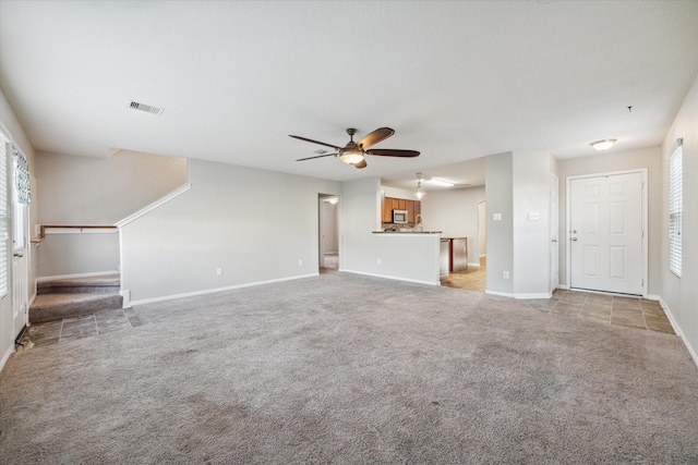 unfurnished living room featuring ceiling fan and light colored carpet