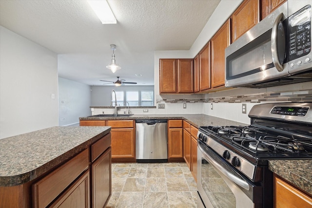 kitchen featuring pendant lighting, sink, ceiling fan, a textured ceiling, and appliances with stainless steel finishes