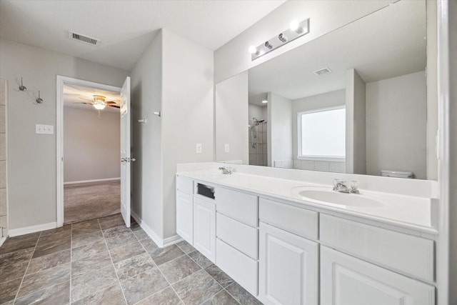 bathroom with a shower, vanity, toilet, and ceiling fan