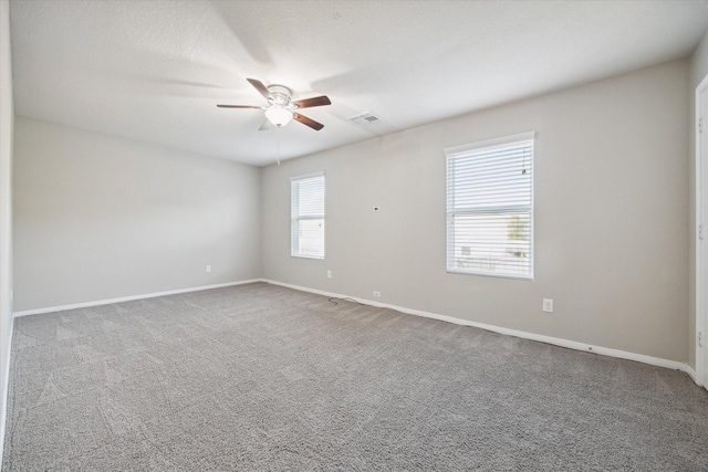 unfurnished room with ceiling fan and carpet