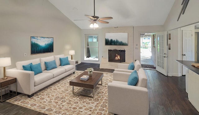 living room featuring ceiling fan, wood-type flooring, a fireplace, and high vaulted ceiling