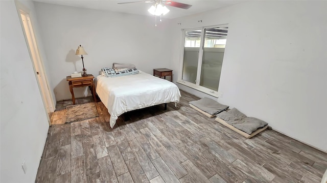 bedroom with hardwood / wood-style flooring, ceiling fan, and baseboard heating