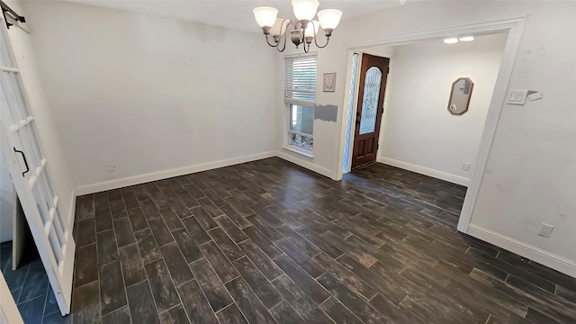 interior space with a notable chandelier, a barn door, and dark wood-type flooring