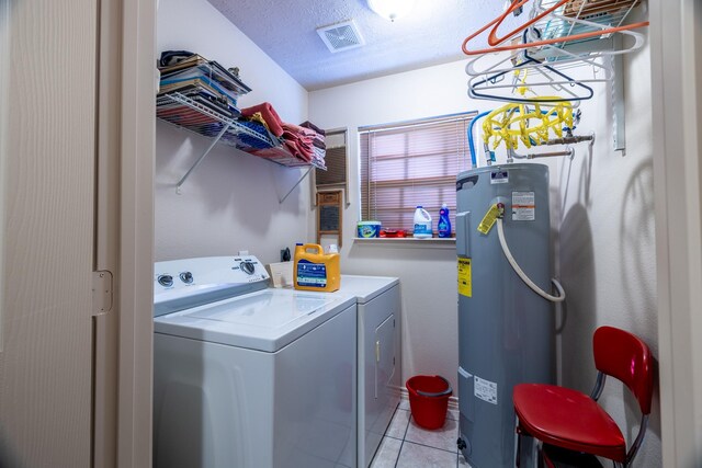 washroom with washer and dryer, light tile patterned floors, electric water heater, and a textured ceiling