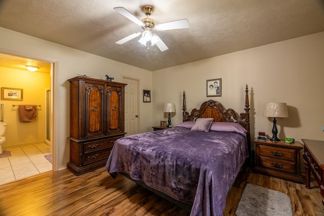 bedroom featuring a textured ceiling, connected bathroom, light hardwood / wood-style flooring, and ceiling fan