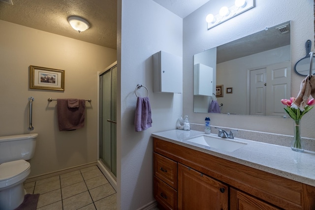 bathroom featuring tile patterned floors, a shower with door, vanity, and toilet