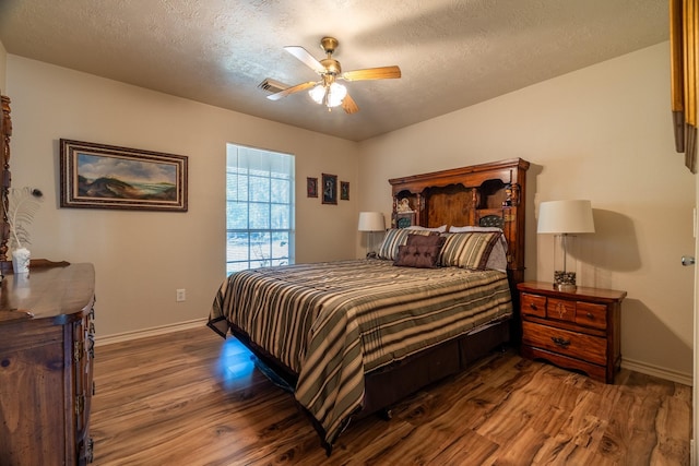 bedroom featuring a textured ceiling, ceiling fan, and dark wood-type flooring