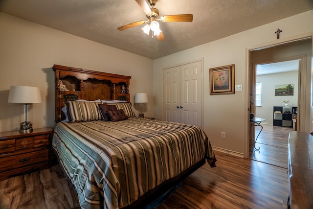 bedroom with a textured ceiling, dark hardwood / wood-style flooring, a closet, and ceiling fan