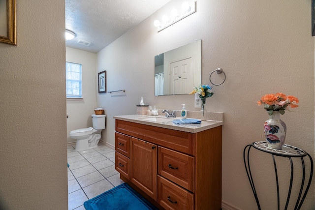 bathroom featuring tile patterned flooring, vanity, toilet, and a textured ceiling