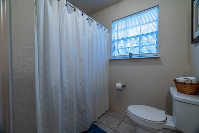 bathroom featuring tile patterned flooring, toilet, and a textured ceiling