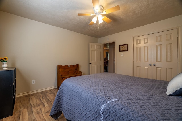 bedroom featuring wood-type flooring, a textured ceiling, a closet, and ceiling fan