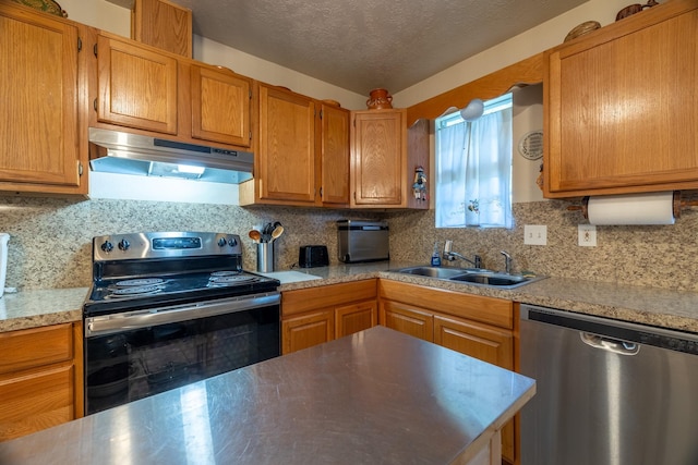 kitchen with decorative backsplash, a textured ceiling, stainless steel appliances, and sink