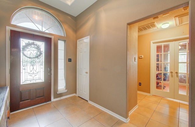 foyer entrance with french doors and light tile patterned flooring