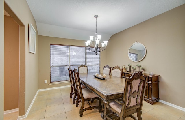 dining area with a chandelier, light tile patterned floors, and vaulted ceiling