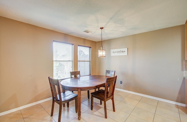 dining room with light tile patterned floors and a textured ceiling