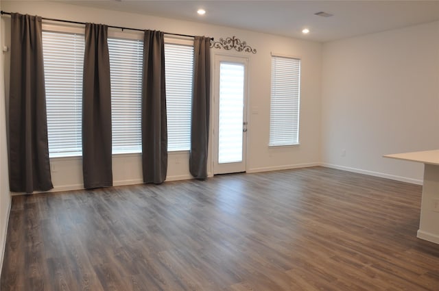 unfurnished room featuring dark hardwood / wood-style flooring and a wealth of natural light