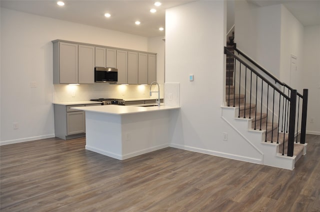 kitchen featuring gray cabinetry, sink, appliances with stainless steel finishes, dark hardwood / wood-style flooring, and kitchen peninsula