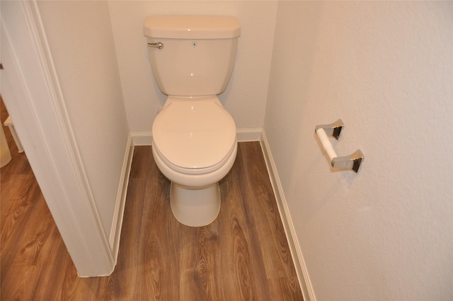 bathroom featuring wood-type flooring and toilet