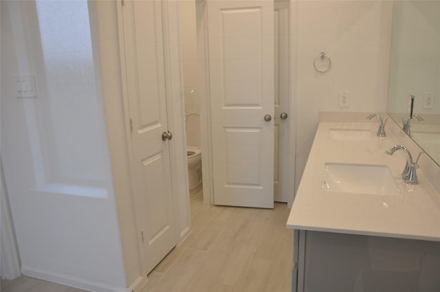 bathroom with hardwood / wood-style flooring, vanity, and toilet