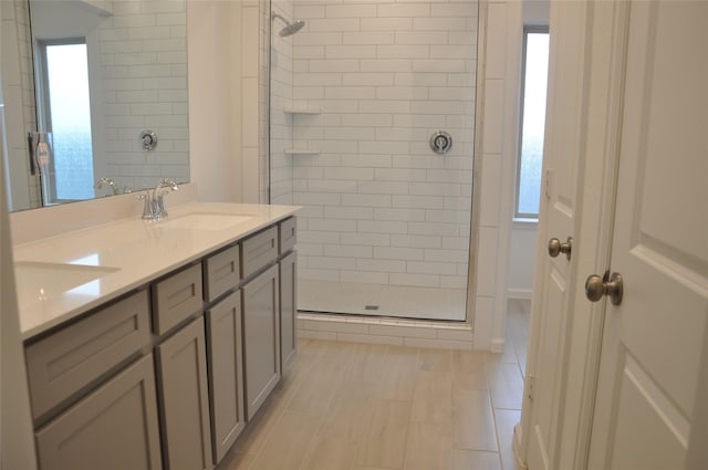 bathroom with a tile shower and vanity