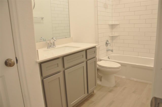 full bathroom with vanity, tiled shower / bath, and toilet