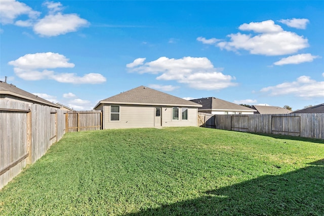 rear view of house featuring a yard