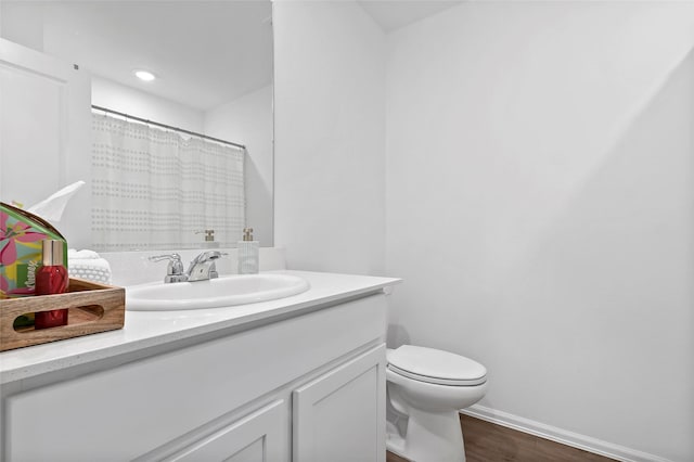 full bath with vanity, a shower with curtain, wood finished floors, baseboards, and toilet