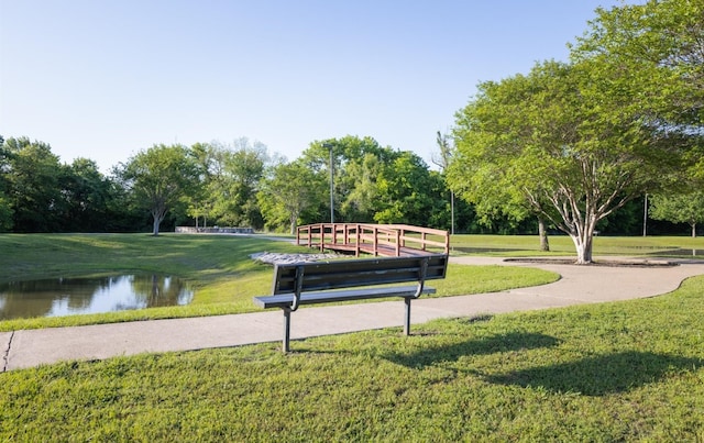 view of property's community with a water view and a yard