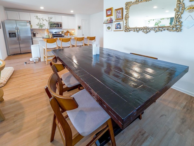 dining room with recessed lighting and light wood finished floors