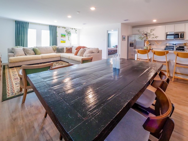 dining room with recessed lighting and light wood-style flooring