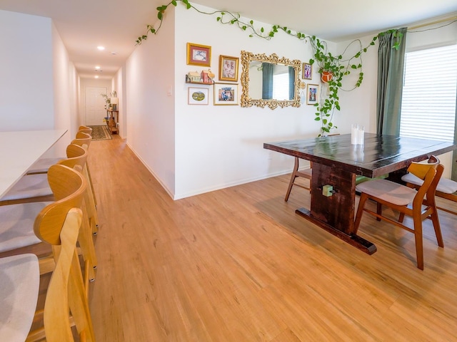 dining space with baseboards and light wood finished floors