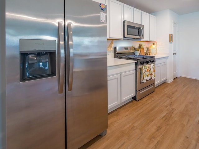 kitchen with light wood-style flooring, white cabinetry, stainless steel appliances, and light countertops