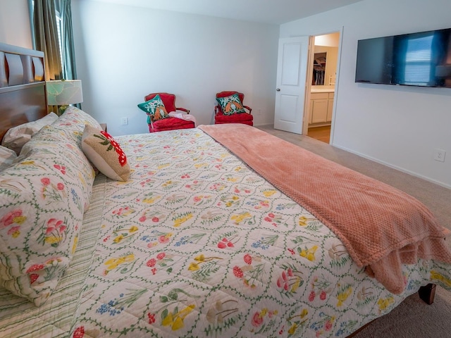 carpeted bedroom featuring baseboards and ensuite bath