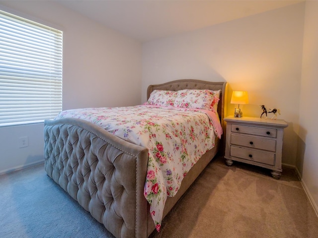 bedroom featuring baseboards and light carpet