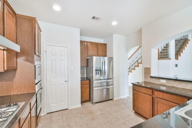 kitchen with tasteful backsplash, light tile patterned floors, and appliances with stainless steel finishes