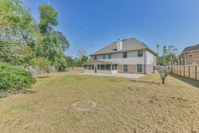 back of property featuring a sunroom, a patio area, and a lawn