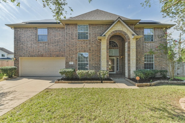 view of front of property with solar panels, a garage, and a front yard